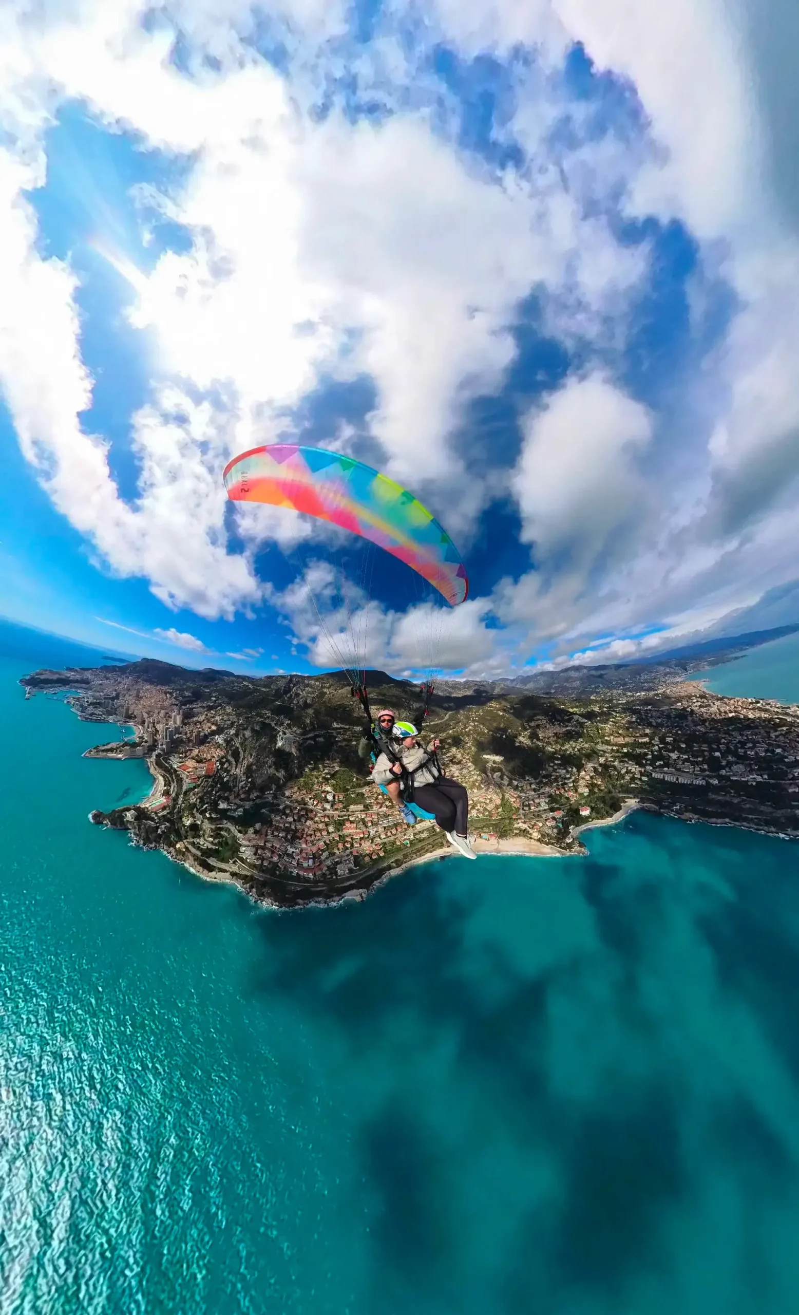 Vol en parapente biplace au-dessus de la mer Méditerranée en région PACA, entre ciel bleu et paysages côtiers spectaculaires.